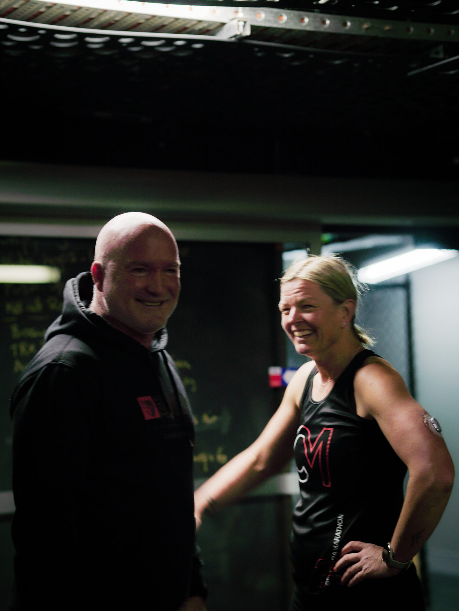 A coach and a member laughing between efforts