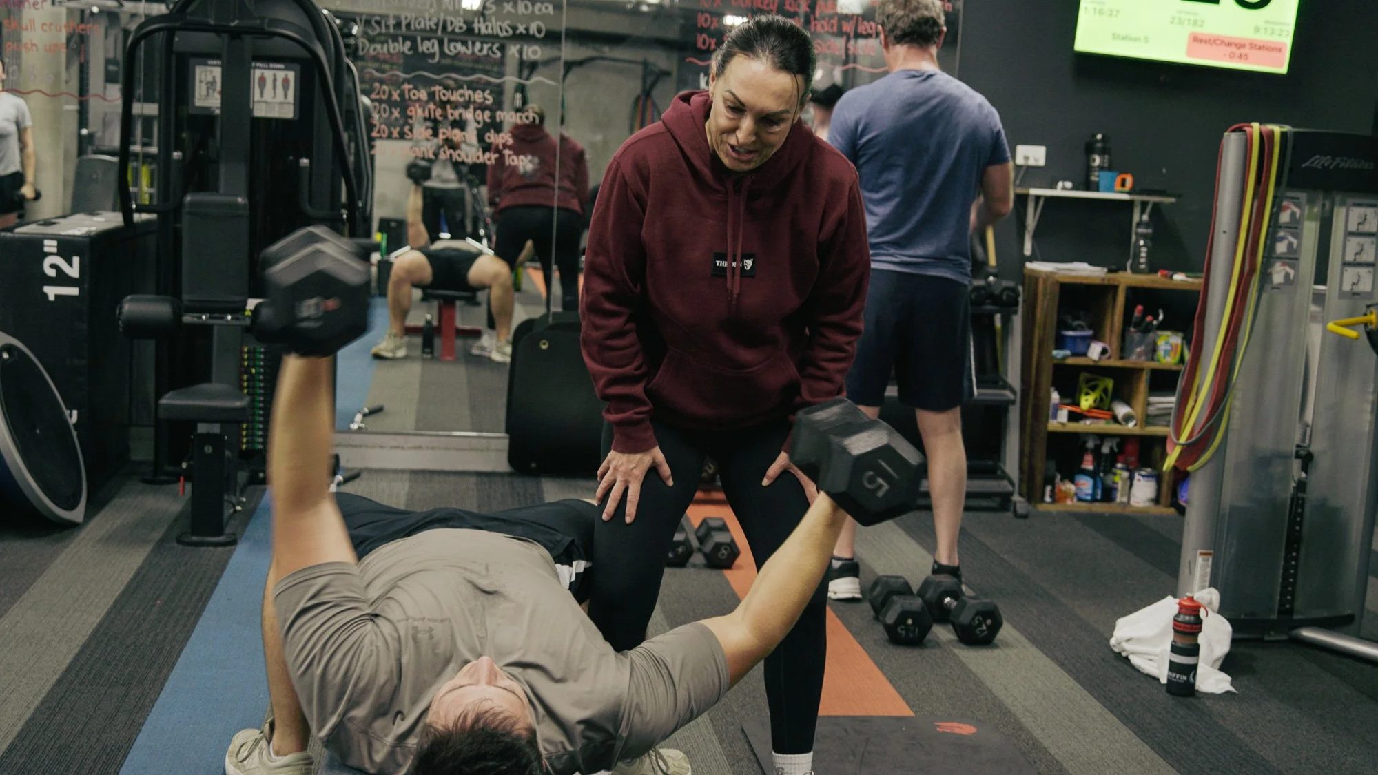 A coach guiding a member through a lift