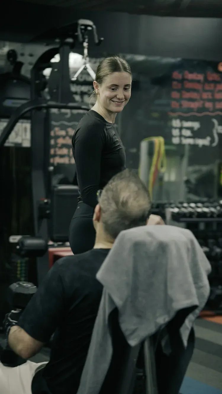 A coach checking in with a member between sets